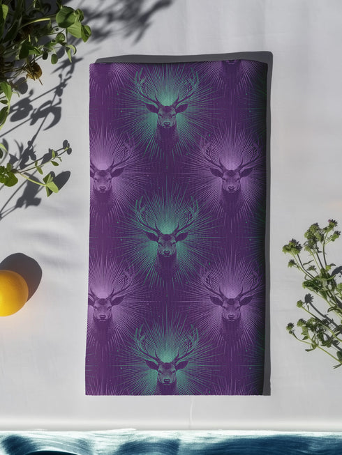 Set of four purple dining napkins featuring alternating teal and violet stag heads with radiating sunburst patterns, sized 18x18 inches.